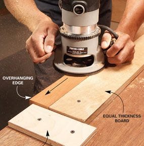 Woodworker holding a router on the edge of a board