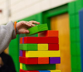Person stacking colorful blocks on top of each other.