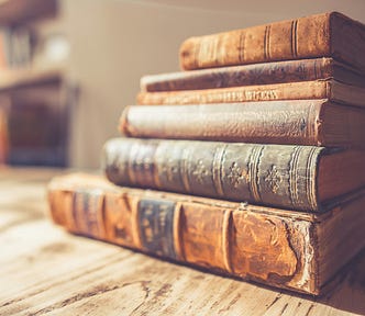 A stack of old books on a wooden table