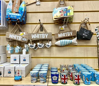 A variety of gifts such as snowglobes and glasses in a seaside gift shop.