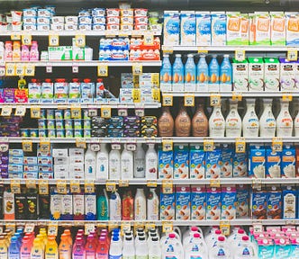 A grocery store shelf filled with various dairy products, including milk, yogurt, and beverages.