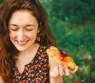 A woman eating pastry.