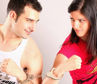 A man and a woman shackled together with handcuffs.