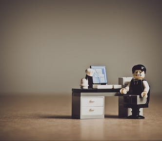 Lego character at a tiny computer
