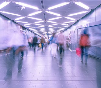 A picture of a large number of people walking in a subway station