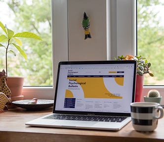 A laptop by the window with a morning coffee.