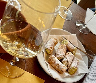a vineyard tasting of white wine and delicious canoli on a table