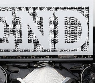 Black and white image where you see the top part of a typewriter, a paper with many letters on it and in white, it says ‘END’.