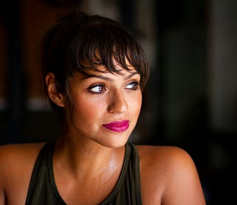 Woman looking thoughtful against a dark background