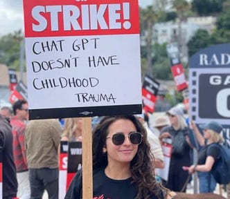 Young woman holding protest sign reading “ChatGPT doesn’t have childhood trauma.”