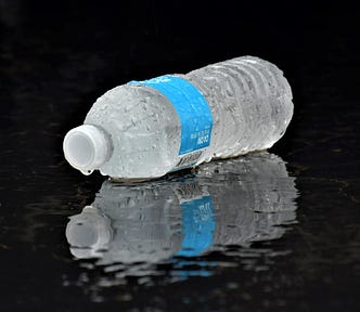 picture of water bottle laying on side with reflection