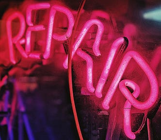Pink neon sign with word Repair