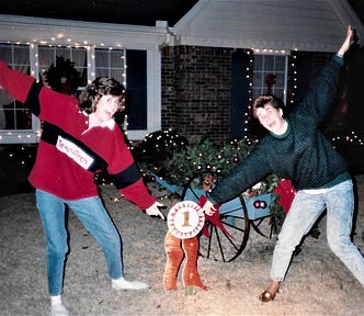 Author with her sister in front of their family home. Showing off the First Prize ribbon for the house Christmas Decorations. Circa 1987.