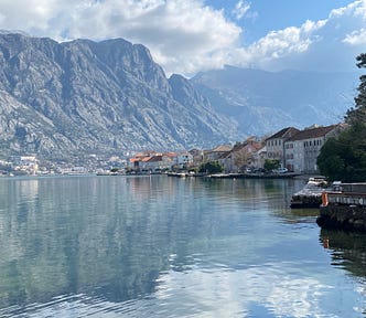 Dramatic mountains drop into the water and a small village is on a peninsula into the inlet.