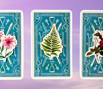 Three tarot pick a card piles: pile 1 — pink flowers, pile 2 — green plant, and pile 3 — red flowers