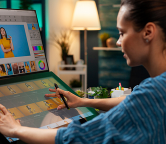 A girl working on editing a photo with a Python logo displayed on the screen.