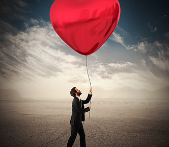 a man walking in a desert holding a giant balloon shaped like a love heart, garrulous glaswegian, medium