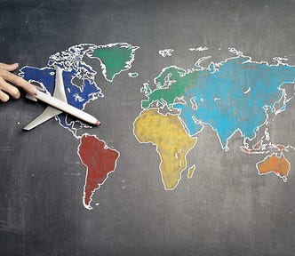 Model airplane sitting on a colorful map of the world.