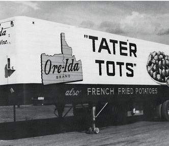 Vintage black and white photo of a semi-tractor trailer with the Ore-Ida brand logo and a large picture of Tator Tots stacked up pyramid-style on a plate. It says Tater Tots in large letters on the side as well.