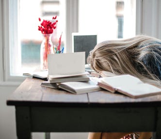tired woman with head on desk