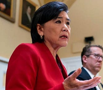 Representative Judy Chu in red suit speaking in a Congressional meeting