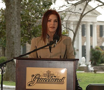 Priscilla Presley standing in front of Graceland