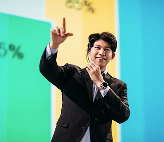 Asian man presenting on stage in front of Data Visualization
