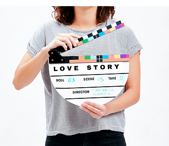 Woman holding a movie clipboard featuring the words Love Story, ready for action