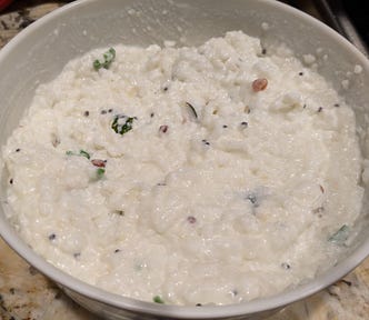 A bowl of curd-rice, a savory Indian dish made with yogurt, rice and a tempering of mustard seeds, curry leaves and hot green chili peppers.