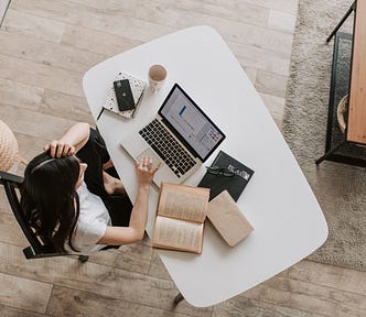 young lady using laptop at table in modern workspace
