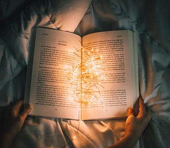 Lit string lights sitting on top of open book