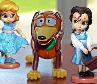 Belle and Aurora figurines flirting with a Slinky Dog toy.