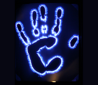 A Kirlian photograph of a human hand displaying the blue coronal electrical discharge