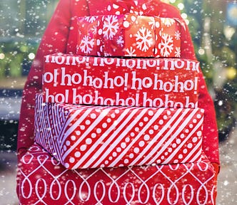 Woman holds stack of packages in red holiday wrapping