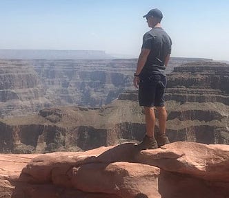 Man standing on the edge of the Grand Canyon overlooking miles of scenery