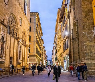 city street in florence italy at night with people walking around. The Honeymoon That Rebirthed and Empowered My Love of Adventure by Nancy Blackman. travel, honeymoon, florence, italy, adventure