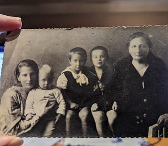 a photo of an old family photograph, with author’s great grandma, grandma, and father, uncle and aunt as children