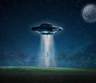 Two people getting abducted by a flying saucer at night, over a green field. A full moon is also visible on the top right corner.