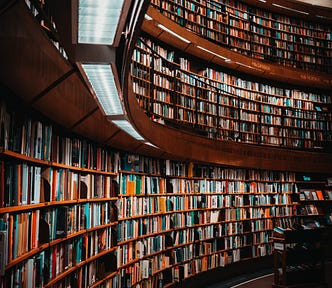 A vintage-style library with curved bookshelves filled with books.