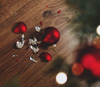 broken red glass Christmas tree ornament on wood floor