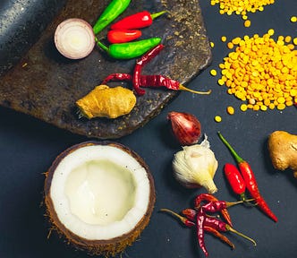 Indian spices. Coconut, pepper, dried chili, coriander, ginger, onions on grinding stone
