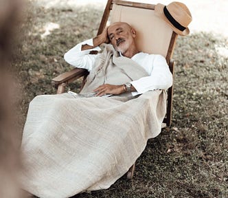 Older man asleep in lawn chair.