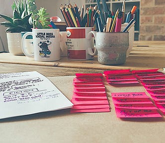 A sheet of brown paper with small post its stuck on. The post its represent the tasks that need to be done to achieve the big goal.