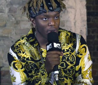 KSI vs Ivan Nikolov vs Swarmz — KSI speaks into an MTV microphone. He looks well dressed in a golden-white sleeve and infamous bandana.