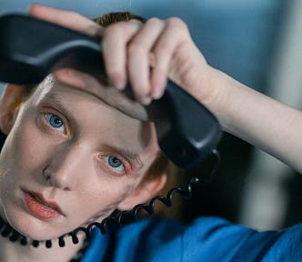 An editor about to almost strangle herself with the wire from a phone