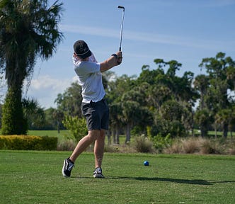 Golfer following through a little past halfway