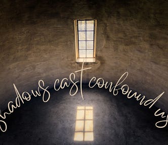 A long rectangular window reflected on the floor of a darkened, curved room. The words, ‘shadows cast confound us’ form a arc in the centre of the image.