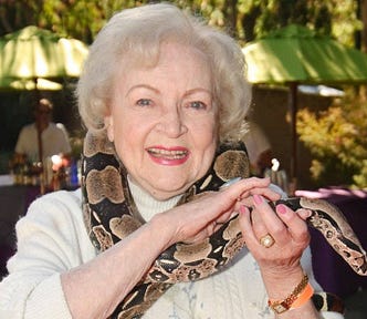 Betty White with a boa constrictor around her neck and a big smile on her face