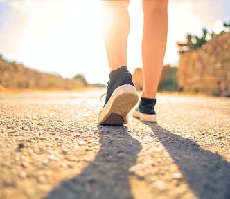 Woman Walking on Pathway Under The Sun. What happens when you walk more than 20k steps per day