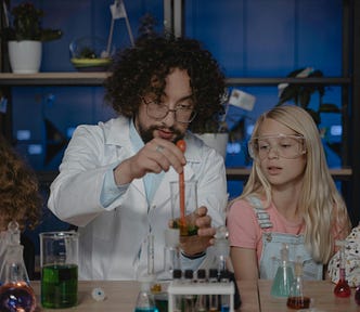 Chemistry teacher carrying out an experiment with a test tube in front of pupils.
